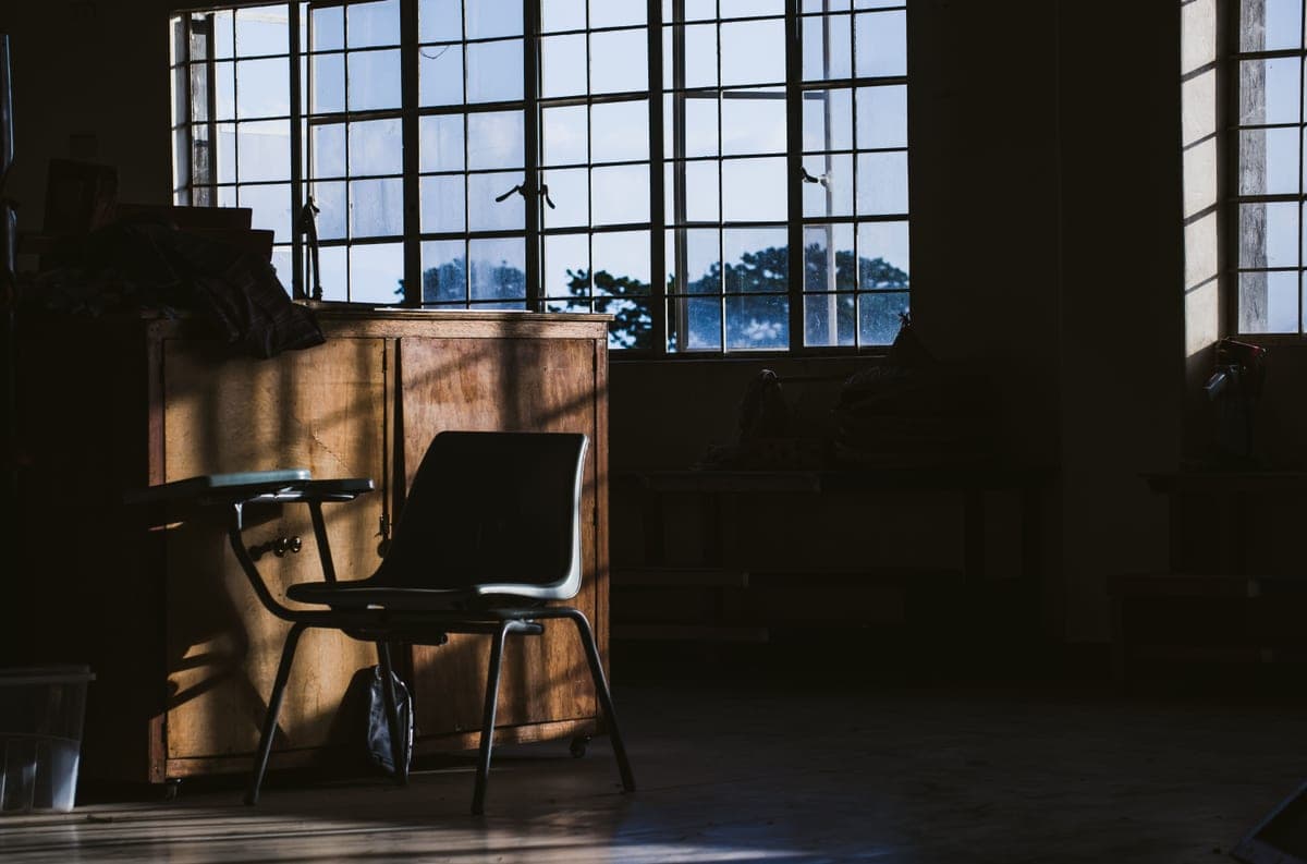 A dining chair beside a sunlit window in a home interior
